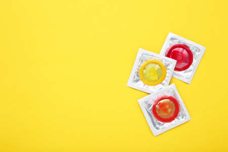 Colorful condoms on yellow backgroundの写真素材