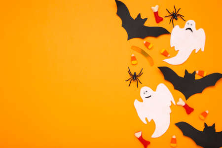 Halloween paper bats, ghost with candies and spiders on orange backgroundの写真素材