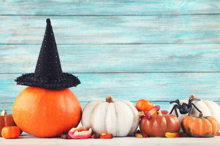 Halloween pumpkins, candies, black hat and spider on blue backgroundの写真素材