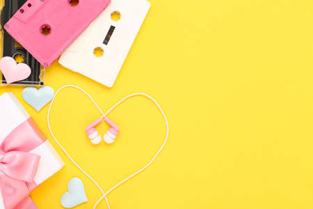 Earphones with cassette tapes and gift box on yellow backgroundの写真素材