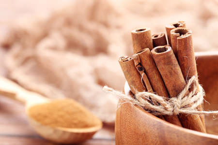 Cinnamon sticks and powder on brown wooden backgroundの写真素材