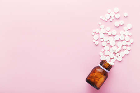 Medicine pills and bottle on pink backgroundの写真素材