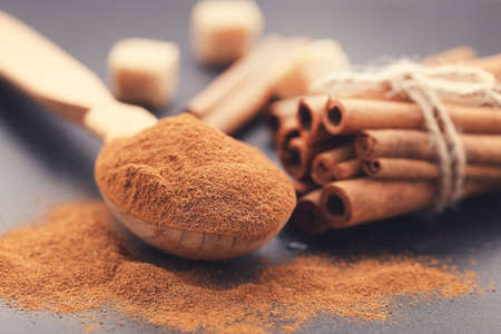 Cinnamon powder with sticks and sugar on black backgroundの写真素材