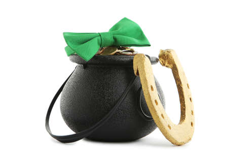 Pot of coins with green bow tie and golden horseshoe isolated on white background. Concept St.Patrick's Dayの写真素材