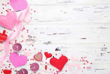 Valentines hearts with ribbon and candles on white wooden backgroundの写真素材