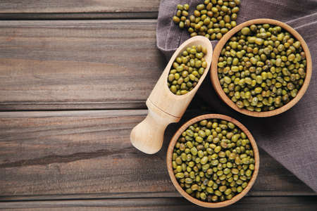 Soy beans with bowls and scoop on wooden backgroundの写真素材