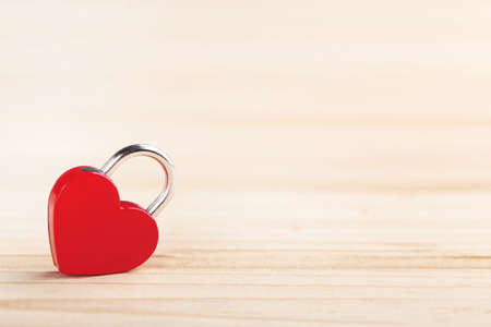Red padlock in shape of heart on wooden backgroundの写真素材