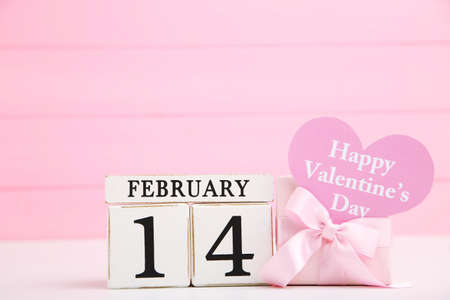 Gift box with text Happy Valentines Day and cube calendar on pink wooden backgroundの写真素材