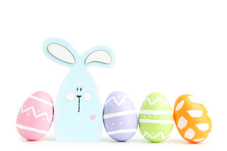 Wooden rabbit and colorful easter eggs on isolated white background