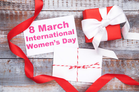 Card with text 8 March International Women's Day, envelope with letter, gift and red ribbon on...