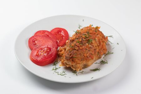 Rice cutlet with beef on a white dish with red tomatoesの写真素材