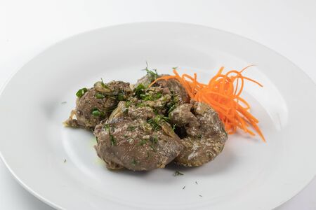 Braised beef liver with carrots on a white dishの写真素材