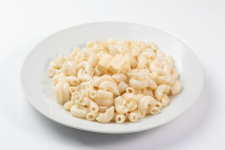 Pasta with two diced butter on a white dishの写真素材