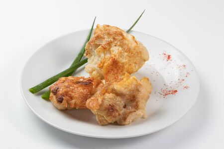 Cauliflower in batter on a white dishの写真素材
