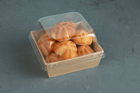 Eco packaging - profiteroles with cream in craft packaging for the delivery service.の写真素材