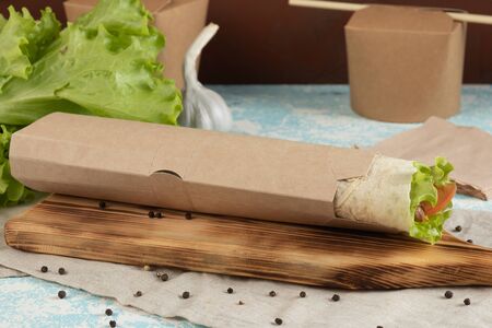 Eco packaging - roll with vegetables and mushrooms in craft packaging for the delivery service....