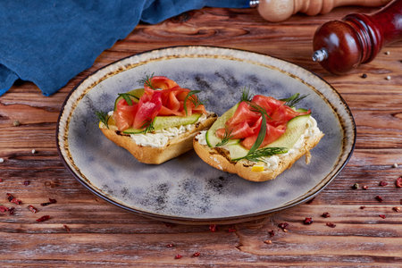 Bruschetta with salmon slices and soft cheese, wooden backgroundの写真素材