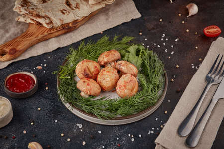 Grilled champignon mushrooms, textured dark background