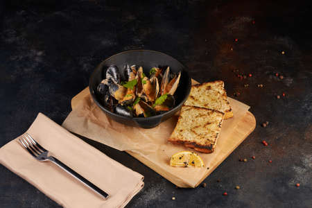 Fried mussels with bread slice, dark backgroundの写真素材