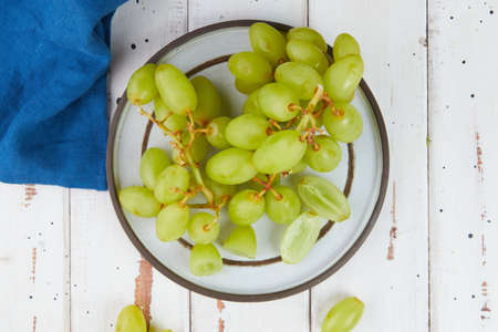 Bunches of fresh ripe green grapes on a wooden table
