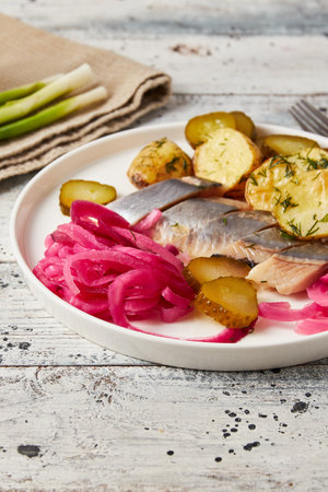 Herring with baked potato, onions and pickled cucumber, closeupの写真素材