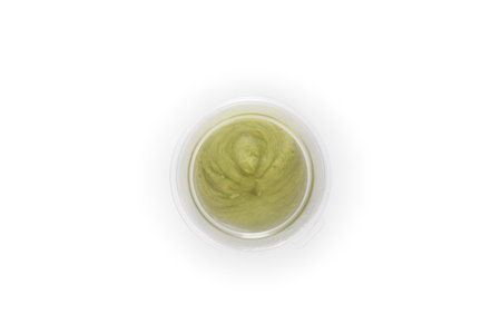 Green hot wasabi condiment in plastic jar isolated on whiteの写真素材