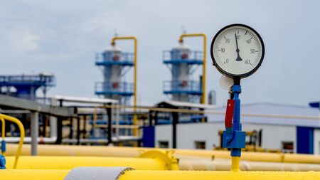 The gas pipeline is yellow with additional equipment, pipes and a valve to shut off the gas supply....