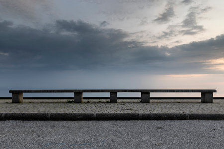 bench in front of a sky with clouds