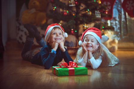 Happy children with Christmas gift, joy.の写真素材