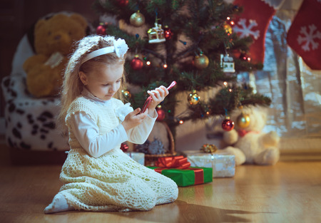 Happy little smiling girl with christmas gift box.の写真素材