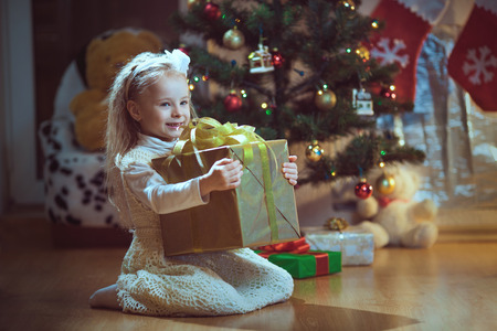 Happy little smiling girl with christmas gift box.の写真素材