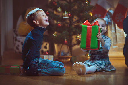 Happy children with Christmas gift, joy.の写真素材