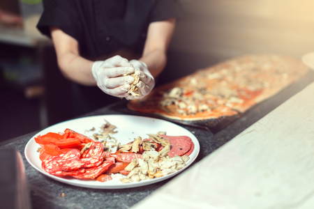Chef prepares the ingredients for pizzaの写真素材