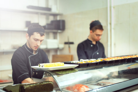 male cooks preparing sushi in the restaurant kitchen.の写真素材