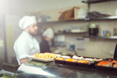 male cooks preparing sushi in the restaurant kitchen.