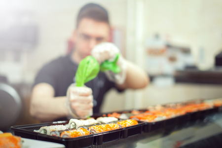 male cooks preparing sushi in the restaurant kitchen.の写真素材