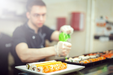 male cooks preparing sushi in the restaurant kitchen.の写真素材