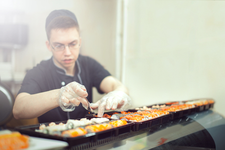 male cooks preparing sushi in the restaurant kitchen.の写真素材