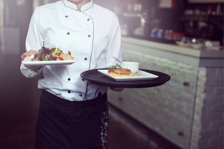 Waiters carrying plates with meat dish at a wedding.の写真素材