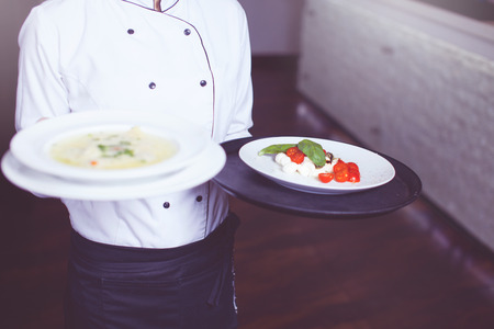 Waiters carrying plates with meat dish at a wedding.の写真素材