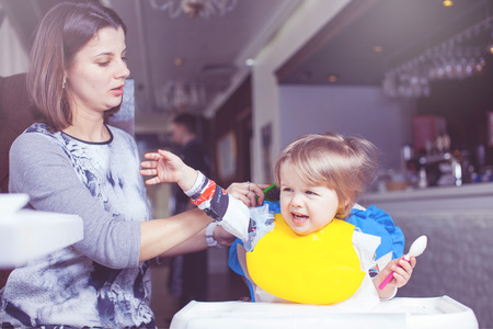 Mother with baby eating in a restaurant.の写真素材