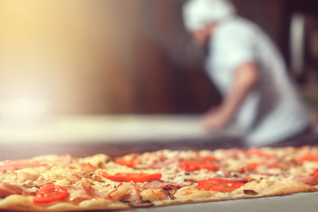 Close-up of pizza, chef behindの写真素材