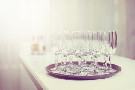 Glasses with white wine on blurred backgroundの写真素材