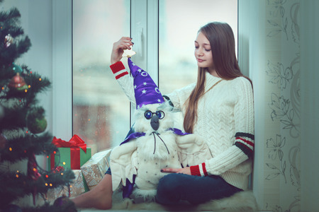 Young beautiful woman with reddish hair sitting home by the windowの写真素材
