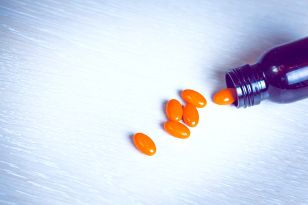 pills in a bottle on wooden background, Medication for treatmentの写真素材