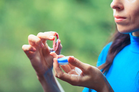 contact lenses in containers and tweezers on green backgroundの写真素材