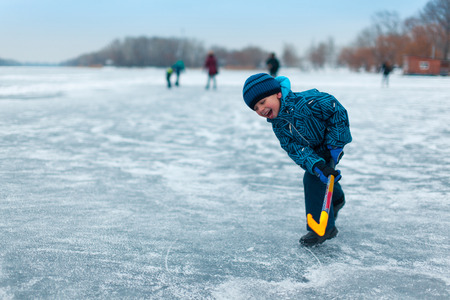 Happy funny kids playing hockey at the rink in the winter.の写真素材