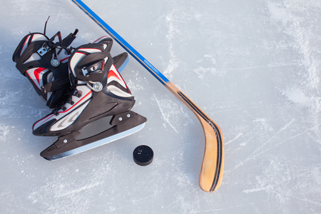 Close-up on hockey puck and hockey equipment in background.の写真素材