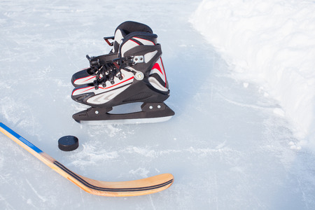 Close-up on hockey puck and hockey equipment in background.の写真素材