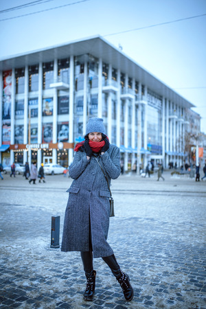 Beautiful and young girl in a hat walking in the evening cityの写真素材